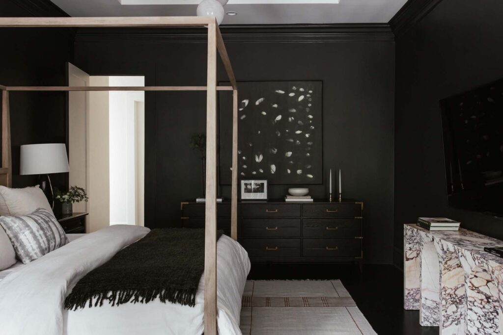 Primary bedroom with black walls and marble credenza