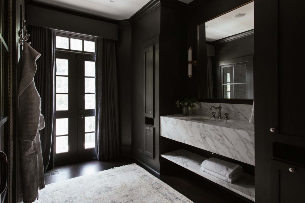 Her bathroom with black walls, no tub, marble counters