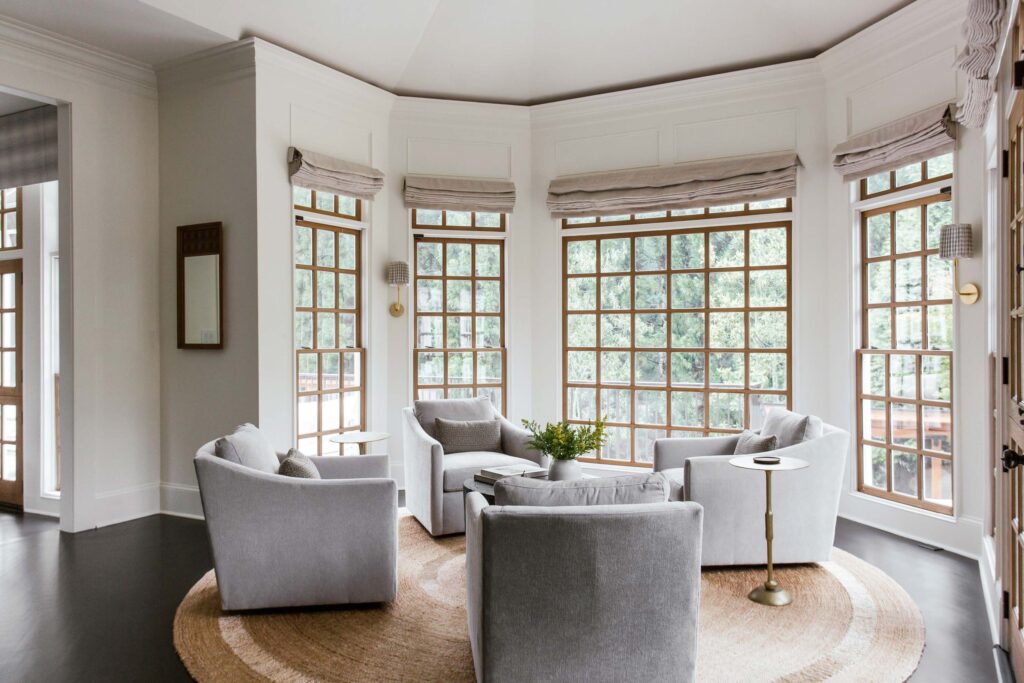 living area with grey lounge chairs and tall bay windows