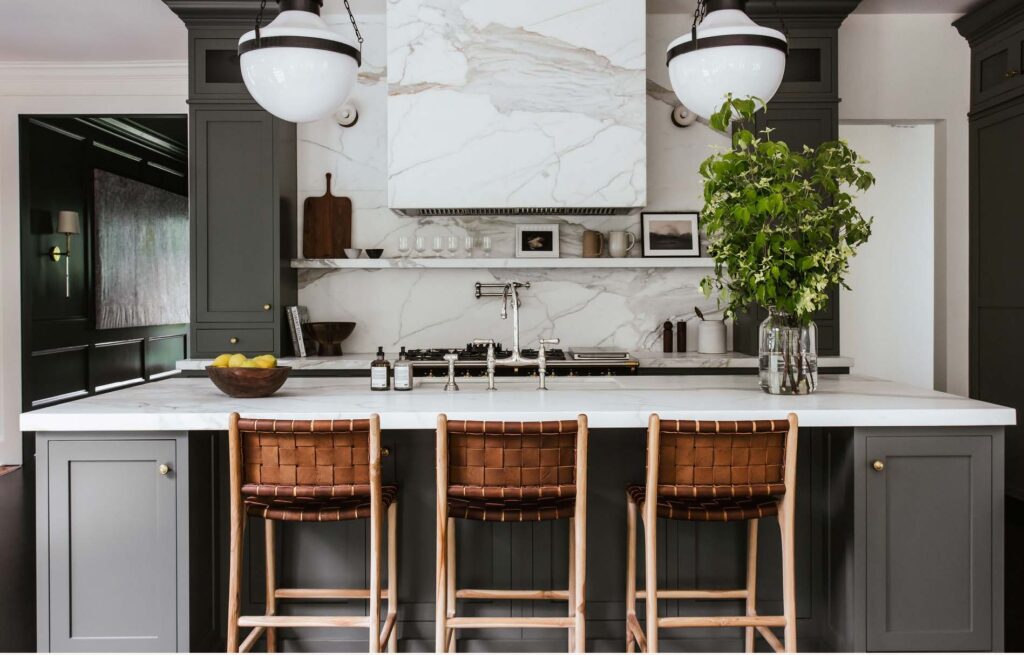 main kitchen island with woven barstools, polished nickel faucet, house plant