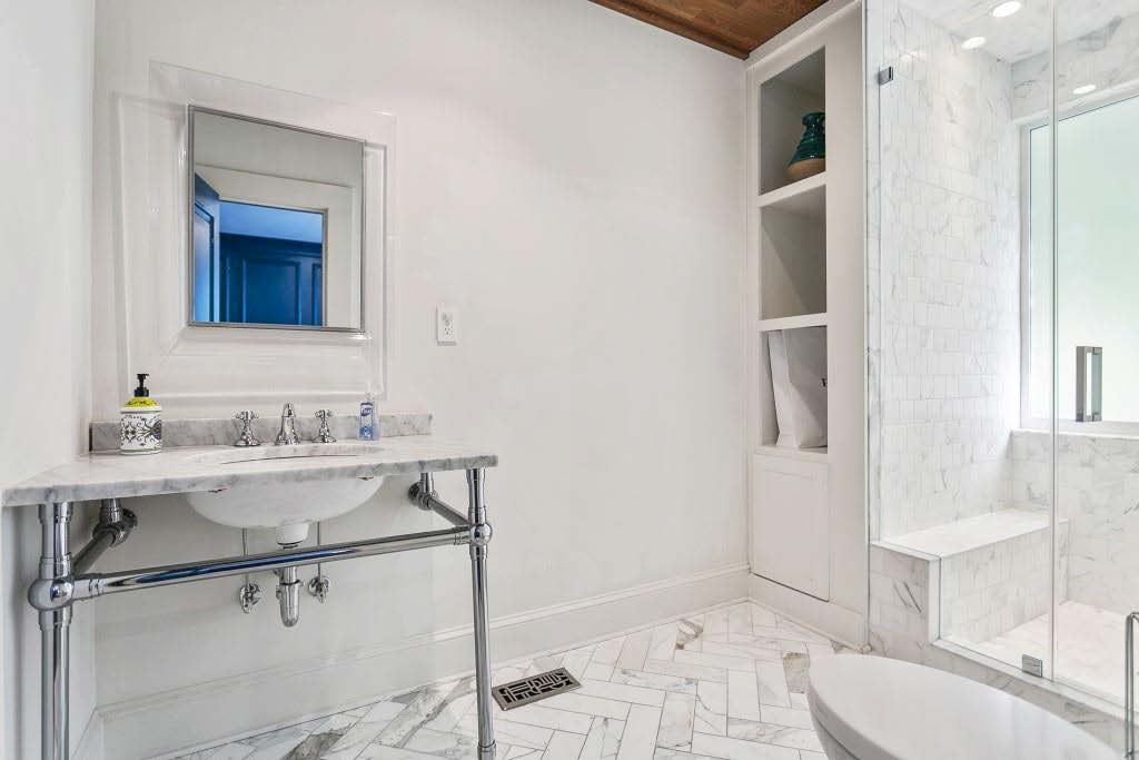 all white marble tile bath with a console sink