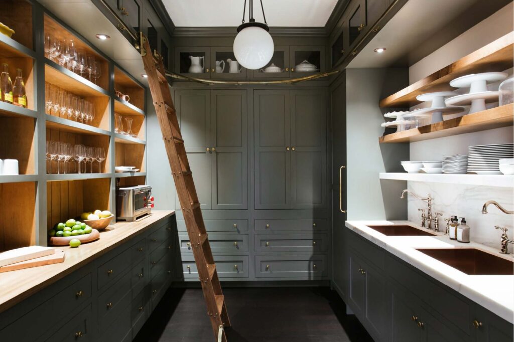 butler's pantry full view with gray cabinets, marble sink and stained open shelving.